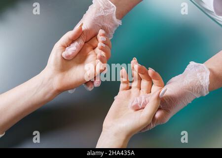 Le manucuriste effectue un massage léger professionnel des mains après la procédure de manucure.Auto-soins mensuels.Un bonus supplémentaire à la procédure dans le salon de beauté.Relaxation des mains après une dure journée.Gros plan Banque D'Images