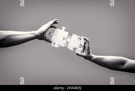 Puzzle à connexion manuelle. Solutions d'affaires, succès et concept de stratégie. Pièce de puzzle main homme reliant couple. Solutions d'entreprise, TARGET Banque D'Images