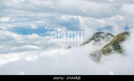 Deux pics de montagne perçant à travers les nuages couvrent le matin, Charlevoix, QC, Canada Banque D'Images