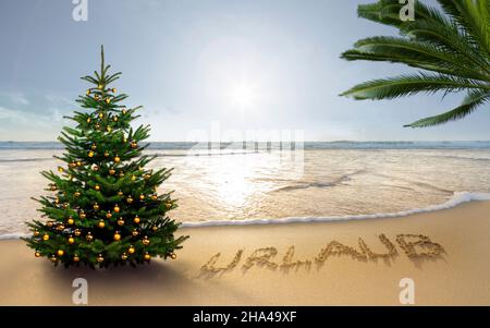 le mot vacances écrit dans le sable sur une plage de mer du sud avec un arbre de noël Banque D'Images