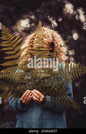 femme tenant de grandes feuilles naturelles dans les bois. concept de sauver la terre de la planète et d'arrêter la déforestation. environnement et les gens dans les activités de loisirs en plein air dans le parc Banque D'Images