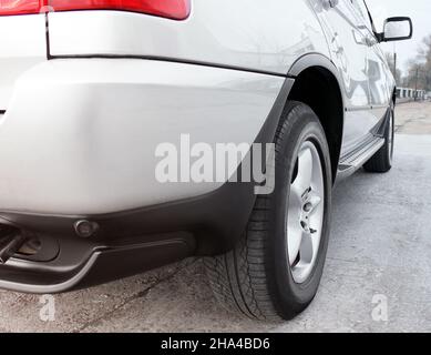 Les roues d'une voiture se rapprochent sur fond d'asphalte.Pneus de voiture.Gros plan de roue de voiture. Pour la publicité (pour la publicité) Banque D'Images