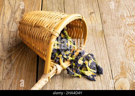 Beaucoup de clitoria sec entier ternatea avec la passoire de bambou sur le vieux bois Banque D'Images