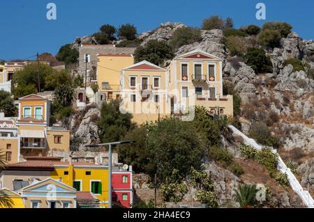 Vue sur baie magnifique avec ses maisons colorées sur la colline de l'île de Symi. Grèce Banque D'Images