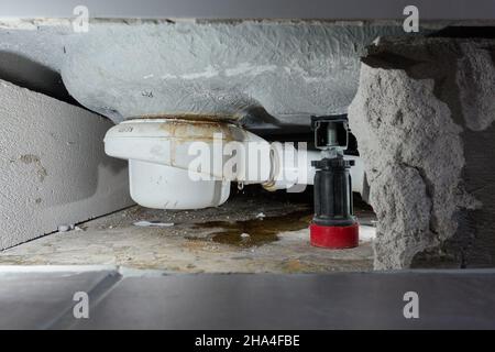 Fuite siphon d'un bac de douche dans la salle de bains, cause des dégâts d'eau.Les carreaux et la maçonnerie ont été retirés pour la réparation et le séchage de la construction.La cause est Banque D'Images