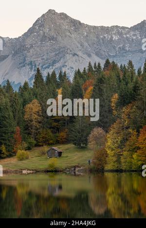 les arbres décolorés en automne sont reflétés dans le geroldsee, derrière eux les montagnes karwendel peuvent être vues, klais, werdenfelser pays, bavière, allemagne Banque D'Images