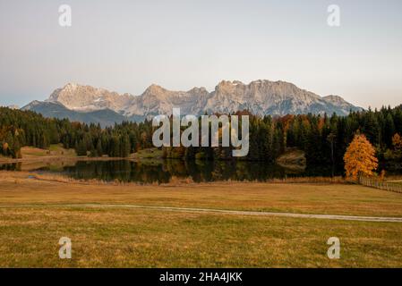 les arbres décolorés en automne sont reflétés dans le geroldsee, derrière eux les montagnes karwendel peuvent être vues, klais, werdenfelser pays, bavière, allemagne Banque D'Images