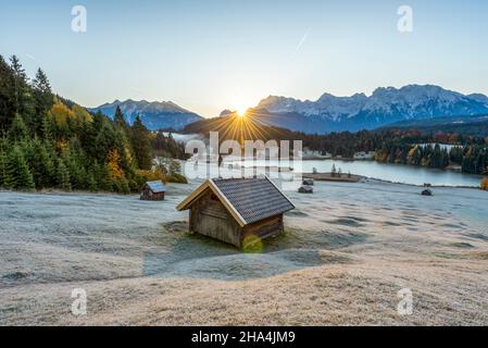 lever du soleil à geroldsee en automne, grange de foin, givre de houar sur les prés de bosse, montagnes de karwendel, klais, pays de werdenfelser, bavière, allemagne Banque D'Images