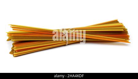 longues pâtes multicolores, spaghetti aromatisés isolés sur fond blanc.Pâtes de fettuccine sèches non cuites attachées dans un paquet isolé sur un backgrou blanc Banque D'Images