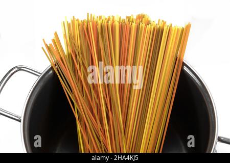 longues pâtes multicolores, spaghetti aromatisés isolés sur fond blanc.Pâtes de fettuccine sèches non cuites dans la marmite isolée sur fond blanc.RA Banque D'Images