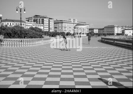 skater fille de patinage et de saut sur terrazza mascagni à livourne, en italie. son grand belvédère sinueux vers la mer avec une surface pavée de 8700 m² comme un damier et 4,100 balusters Banque D'Images