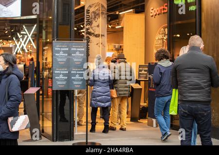 Le vendeur vérifie la carte de vaccination.Les gens font du shopping à Munich, en Allemagne, le 10 décembre 2021.Depuis décembre 8, il y a la règle de 2G, ce qui signifie qu'on doit être vacciné contre le coronavirus ou récupéré du covid-19.(Photo par Alexander Pohl/Sipa USA) crédit: SIPA USA/Alay Live News Banque D'Images