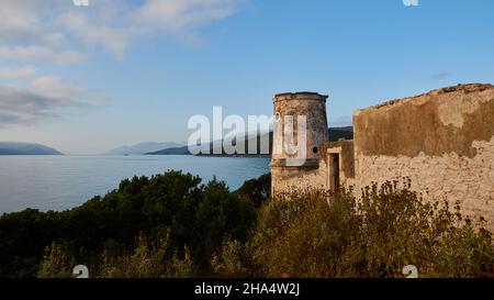 grèce,iles grecques,iles ioniennes,kefalonia,fiskardo,humeur du matin,ciel partiellement nuageux,vue du nord au phare rond vénitien,derrière lui la mer ouverte,en arrière-plan la côte de kefalonia,en premier plan buissons verts,bleu ciel,en haut à gauche nuages blancs isolés Banque D'Images