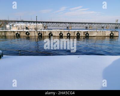 Vue d'hiver sur les jetées de rivière abandonnées sur le Dniepr.Des bornes rouillées dans la neige.Les jetées sont couvertes de neige. Banque D'Images