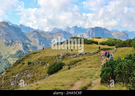 ascension à bärenkopf (1991m), face rocheuse, sentier de randonnée, poney, randonneurs sur les derniers mètres au sommet, en arrière-plan la croix de sommet, nuage humeur dans le ciel, achensee, tyrol, autriche, crête de montagne Banque D'Images