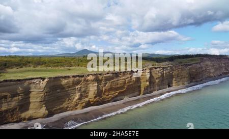 Cascade sur la falaise de Golovinsky sur l'île de Kunashir, îles Kuril, Russie.Photographie aérienne. Banque D'Images