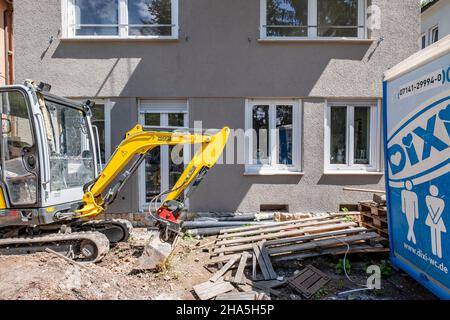 chantier,rénovation et rénovation d'un appartement,petite pelle hydraulique se trouve en face d'une maison rénovée Banque D'Images