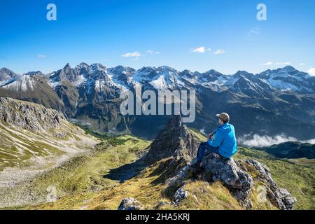 l'homme sur le rossgundkopf jouit de la vue sur les montagnes enneigées de l'allgäu près d'oberstdorf, par un beau jour d'automne. alllgäu alpes, bavière, allemagne, europe Banque D'Images