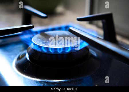 Cuisinière en tant que chauffage.La flamme bleue de la table de cuisson à gaz produit des émissions de gaz à effet de serre.Gaspillage des ressources naturelles.Cuisine cuisinière grille sur un brûleur alimenté par Banque D'Images