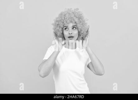 look de fête fantaisie stupéfié. femme freaky dans perruque clown sur fond jaune. exprimer des émotions positives. Banque D'Images