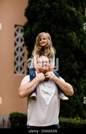 Quatre ans sur les épaules de Dad souriant pour caméra à San Diego Banque D'Images