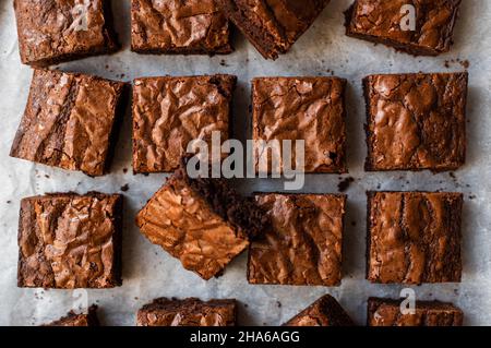 Vue de dessus des brownies au chocolat coupées en carrés sur papier. Banque D'Images