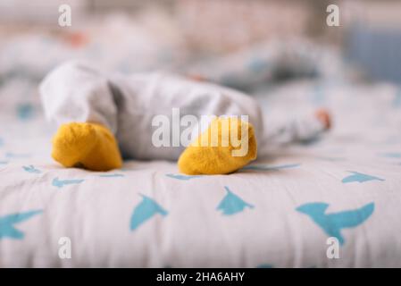 Vue sur les pieds d'un bébé allongé dans le lit. Banque D'Images