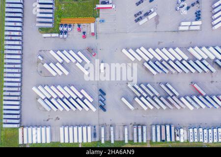 Beaucoup de remorques de fret. Les voitures sont sur plusieurs rangées. Parking camions. Vue aérienne verticale vers le bas. Banque D'Images