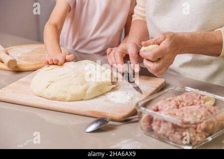 grand-mère et fille préparant un plat de viande Banque D'Images