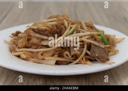 Les nouilles de méin de bœuf au chow font une énorme pile sur l'assiette pour une délicieuse expérience culinaire chinoise. Banque D'Images