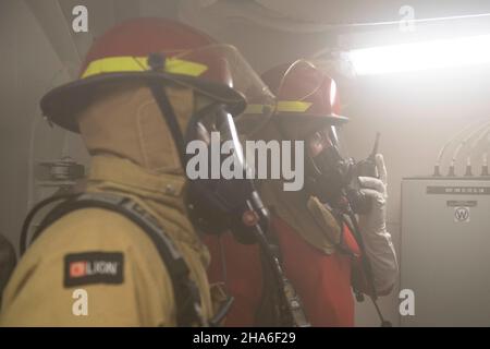 Les membres d'équipage de l'USCGC Stone (WMSL 758) effectuent des exercices d'équipe de formation sur le contrôle des dommages et réagissent à un incendie simulé dans la buanderie à bord du couteau dans l'océan Pacifique, le 23 novembre 2021.La Garde côtière des États-Unis maintient sa volonté de lutter contre les activités maritimes illégales en courant et en répondant aux exercices et aux scénarios chaque jour.(É.-U.Photo de la Garde côtière par l'agent Petty 2nd classe Shannon Kearney) Banque D'Images