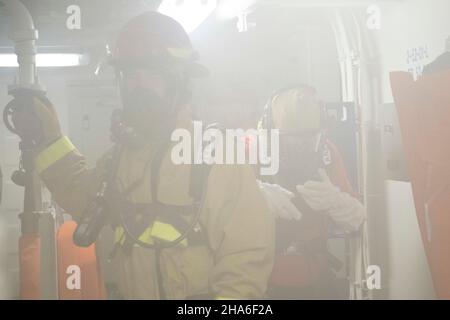 Les membres d'équipage de l'USCGC Stone (WMSL 758) effectuent des exercices d'équipe de formation sur le contrôle des dommages et réagissent à un incendie simulé dans la buanderie à bord du couteau dans l'océan Pacifique, le 23 novembre 2021.La Garde côtière des États-Unis maintient sa volonté de lutter contre les activités maritimes illégales en courant et en répondant aux exercices et aux scénarios chaque jour.(É.-U.Photo de la Garde côtière par l'agent Petty 2nd classe Shannon Kearney) Banque D'Images