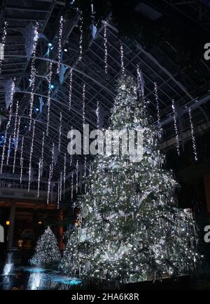 Magnifique sapin de Noël décoré de rubans, de lumières et d'ornements en argent Banque D'Images
