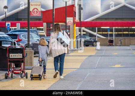 La mère et la fille s'approchent du terminal domestique de l'aéroport international d'Atlanta depuis le niveau supérieur du pont de stationnement.(ÉTATS-UNIS) Banque D'Images