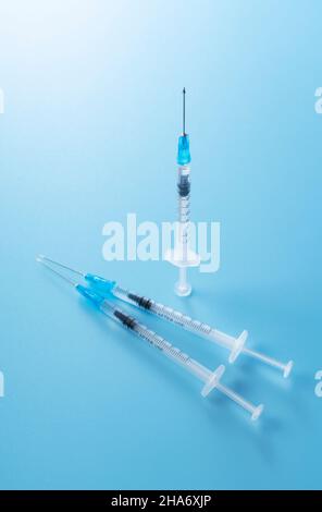 Seringue placée sur fond bleu. Concept de vaccination Banque D'Images