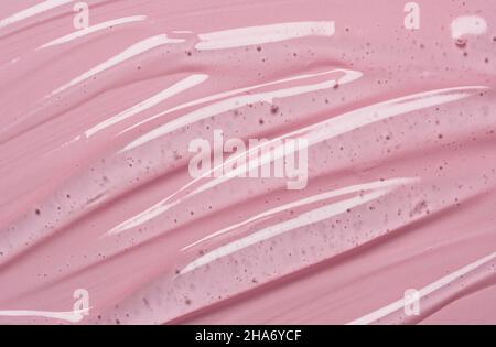 Texture du sérum sur fond de gel liquide transparent avec fond rose.Échantillon transparent de produit de beauté pour la peau. Banque D'Images
