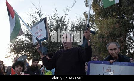 Jérusalem, Israël.10th décembre 2021.Un palestinien tient ses béquilles avec le drapeau palestinien tandis que des militants de gauche israéliens et des Palestiniens criaient des slogans lors d'une manifestation contre l'occupation israélienne et les implantations dans le quartier de Sheikh Jarrah le 10 décembre 2021 à Jérusalem, en Israël.Le quartier palestinien de Sheikh Jarrah est actuellement au centre d'un certain nombre de conflits de propriété entre Palestiniens et Israéliens juifs de droite.Certaines maisons ont été occupées par des colons israéliens à la suite d'une décision du tribunal.Crédit : Eddie Gerald/Alay Live News Banque D'Images