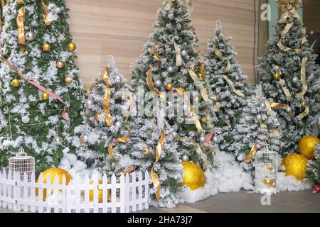 Arbres de Noël décorés de boules d'or et de neige artificielle.Photo de haute qualité Banque D'Images