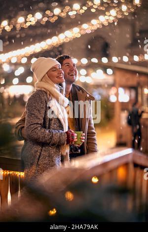 Couple heureux appréciant au festival de noël sur un temps enneigé Banque D'Images