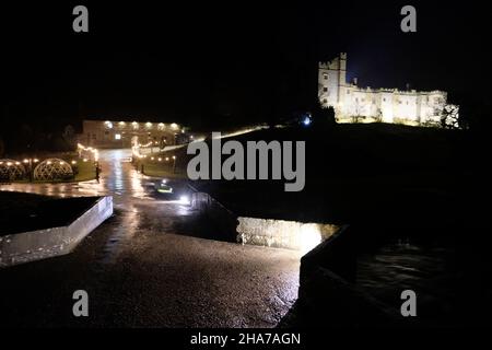 Haddon Hall près de Bakewell, manoir médiéval du Derbyshire illuminé la nuit pour un événement de Noël aux chandelles en décembre, vu depuis le pont au-dessus de la rivière Banque D'Images