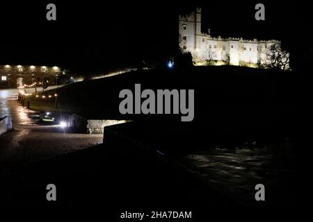 Haddon Hall près de Bakewell, manoir médiéval du Derbyshire illuminé la nuit pour un événement de Noël aux chandelles en décembre, vu depuis le pont au-dessus de la rivière Banque D'Images