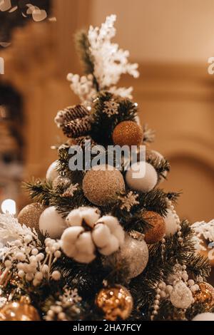 Sapin de Noël confortable décoré de boules de Noël et de coton blanc.Détails de fée, lumières de bokeh brillantes dorées, fête miracle hiver vacances Backgrou Banque D'Images