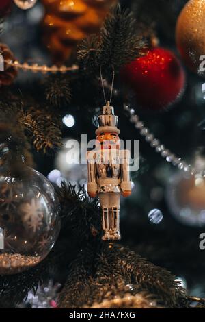 Jouet de Noël blanc casse-noisette suspendu sur l'arbre de Noël.Décoration festive, détails de l'hiver du nouvel an Banque D'Images