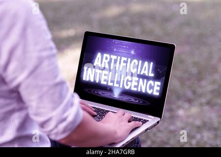 Panneau affichant l'intelligence artificielle.Présentation de l'entreprise copie machine fonction cognitive comme résolution de problèmes femme dactylographiant sur ordinateur portable assis à l'extérieur Banque D'Images