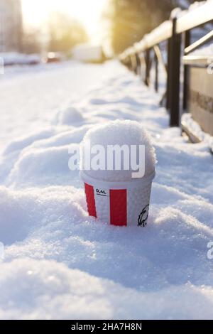 Hot Punch dans une tasse de papier de marque KFS dans une chasse-neige sur la rue d'hiver Banque D'Images