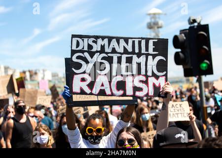 Black Lives protestataires avec démanteler le racisme systémique écriteau Brighton 2020 Banque D'Images