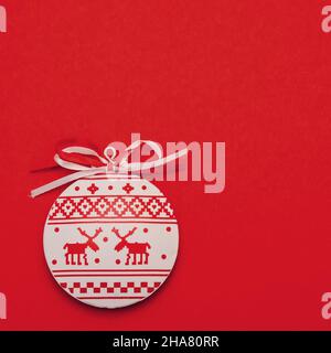 Flat Lay blanc rouge noël minimaliste boule ronde jouet dans le style nordique sur fond rouge vif avec espace de copie Banque D'Images