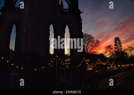 Coucher de soleil sur le monument Scott et la grande roue à Édimbourg avec le marché de Noël Banque D'Images