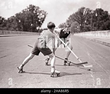 1930S DEUX GARÇONS JOUANT AU HOCKEY DE RUE PORTANT DES VÊTEMENTS D'ÉTÉ SHORT ET MÉTAL PATINS À ROULETTES SUR LA RUE PAVÉ - B1956 HAR001 HARS RÉSISTANCE DE CHAUSSÉE ET DE LOISIRS FLEXIBILITÉ AMICALE MUSCLES BÂTONS PRÉ-ADOLESCENCE SAISON DE GARÇON NOIR ET BLANC RACE BLANCHE HAR001 OLD FASHIONED Banque D'Images