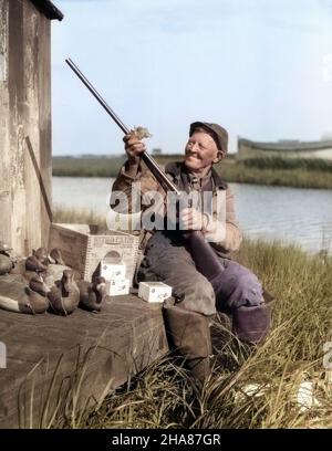 1920S HOMME SOURIANT SENIOR NETTOYANT FUSIL PARKER ENTOURÉ DE LEURRES DE CANARD BOÎTE DE MUNITIONS BARNEGAT BAY NEW JERSEY USA - D665CHAR001 HARS HUNTER HOMME SENIOR AMERICANA ADULTE SENIOR CHASSE VIEILLESSE OLDSTERS OLDSTER AVENTURE COQUILLAGES DECOY ELDERS DUCK HUNTING BAYHOMME LEURRES NEW JERSEY MUNITIONS HOMME ÂGÉ PARKER FUSIL À FEU ARME À FEU CHASSEURS OLD MIKE BARNEGAT BAY ORIGINE ETHNIQUE CAUCASIENNE HAR001 ANSÀ LA MODE Banque D'Images